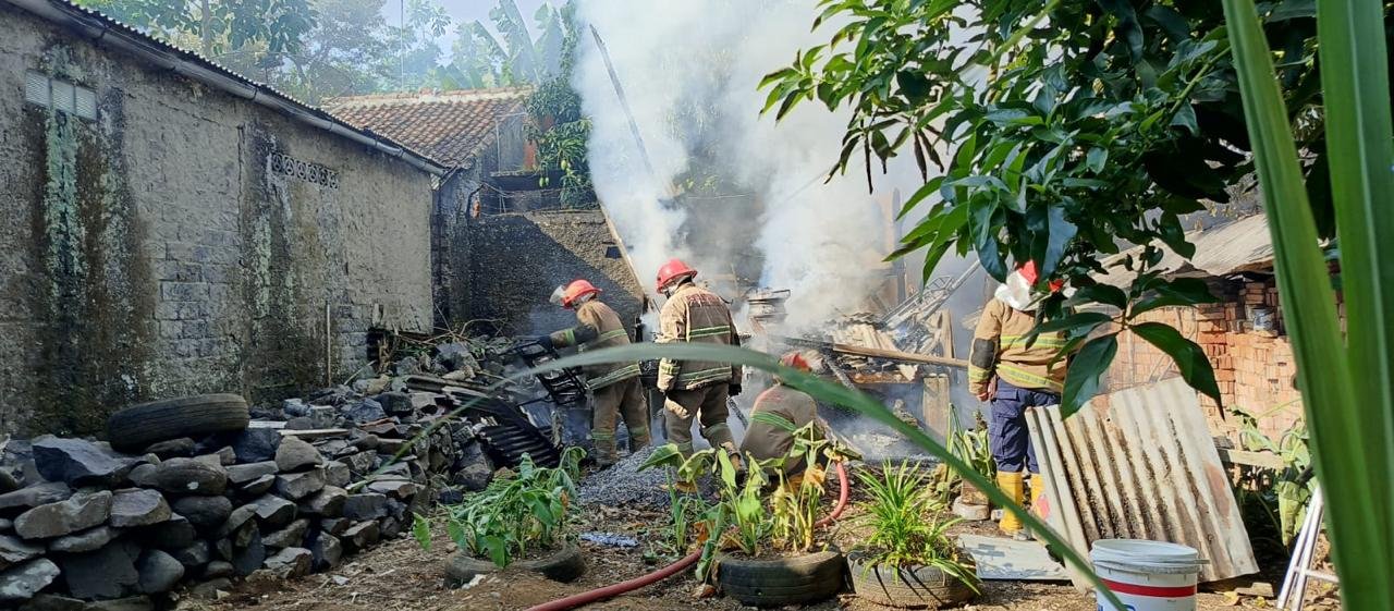 Petugas Damkar Kota Sukabumi saat melakukan pendinginan terhadap gudang yang ludes terbakar, pada Sabtu, 26 Oktober 2024. Foto: Istimewa.
