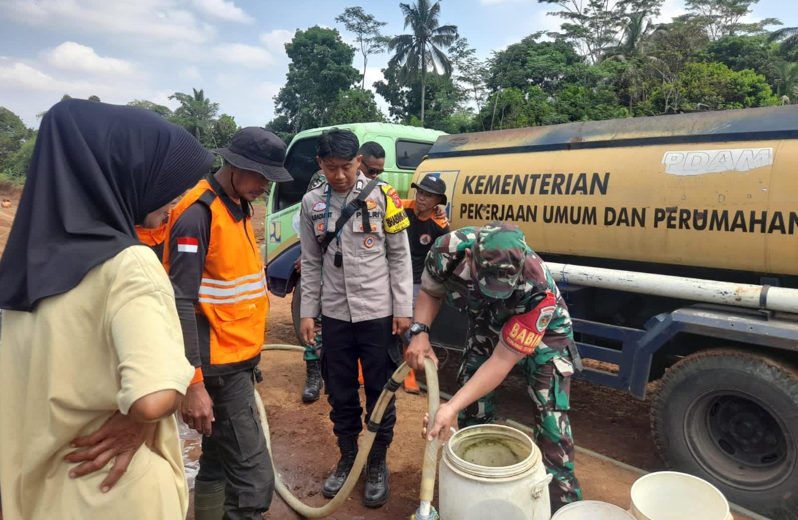 Anggota Koramil 0607-10/Nagrak bersama dengan pemerintah setempat mendistribusikan air bersih kepada warga di Kampung Cangkore, Desa Cisarua, Kecamatan Nagrak, pada Selasa, 30 Oktober 2024. Foto: Pendim 0607 for HALOSMI.