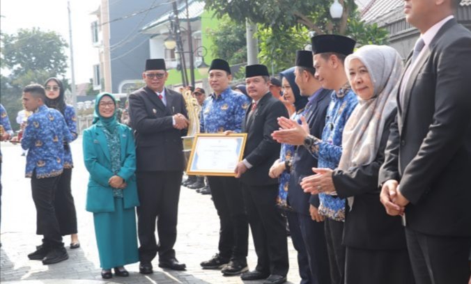 Pj Wali Kota Sukabumi, Kusmana Hartadji, memberikan penghargaan kepada Bidang Perikanan DKP3 yang meraih peringkat pertama dalam KIKS 2024. Foto: Istimewa.