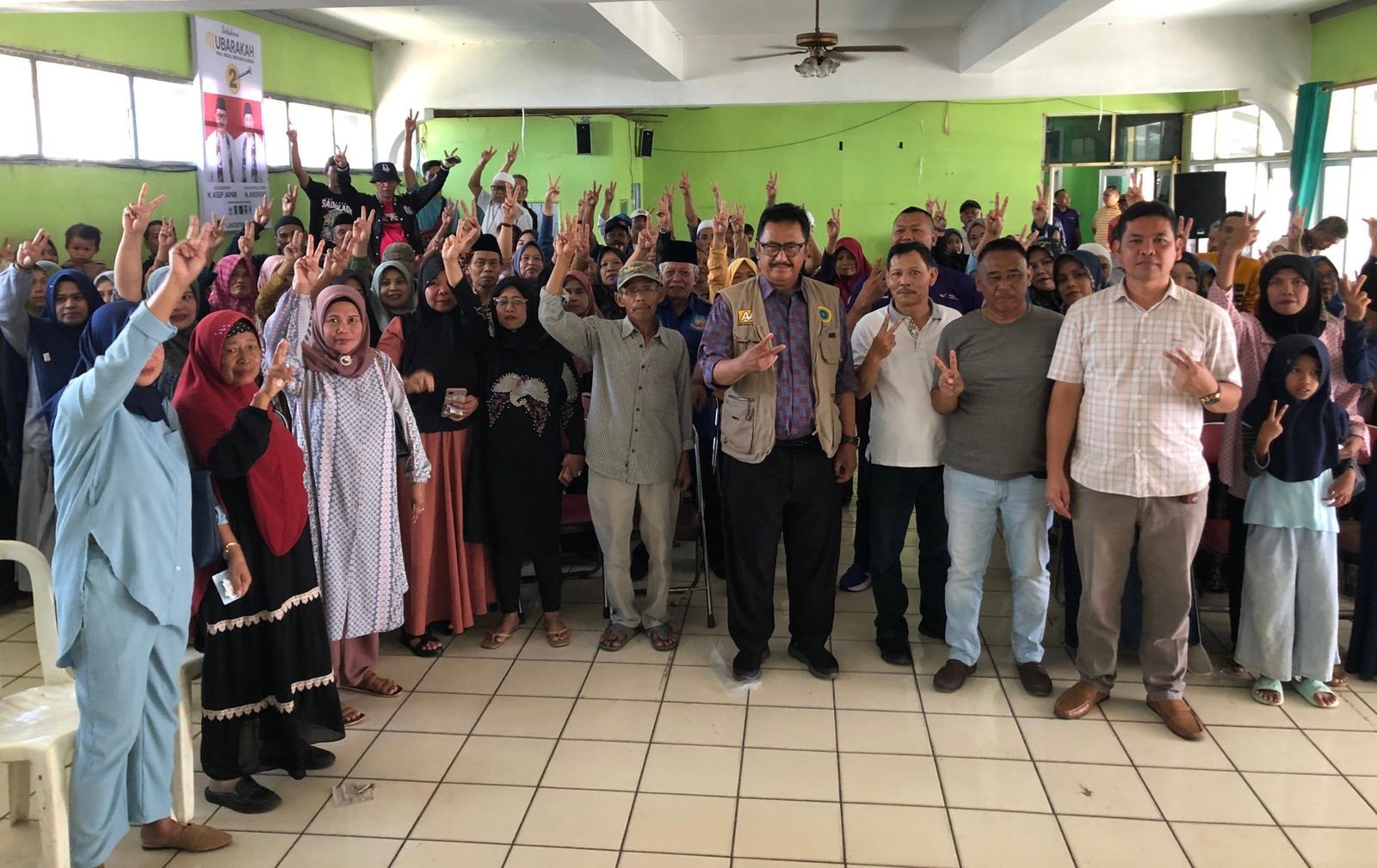 Calon Bupati Sukabumi nomor urut 2, Asep Japar (tengah, memakai rompi) berfoto bersama warga di sela pemeriksaan kesehatan gratis di Kecamatan Cisaat, Sabtu 2 November 2024. FOTO: Heryadie/HALOSMI