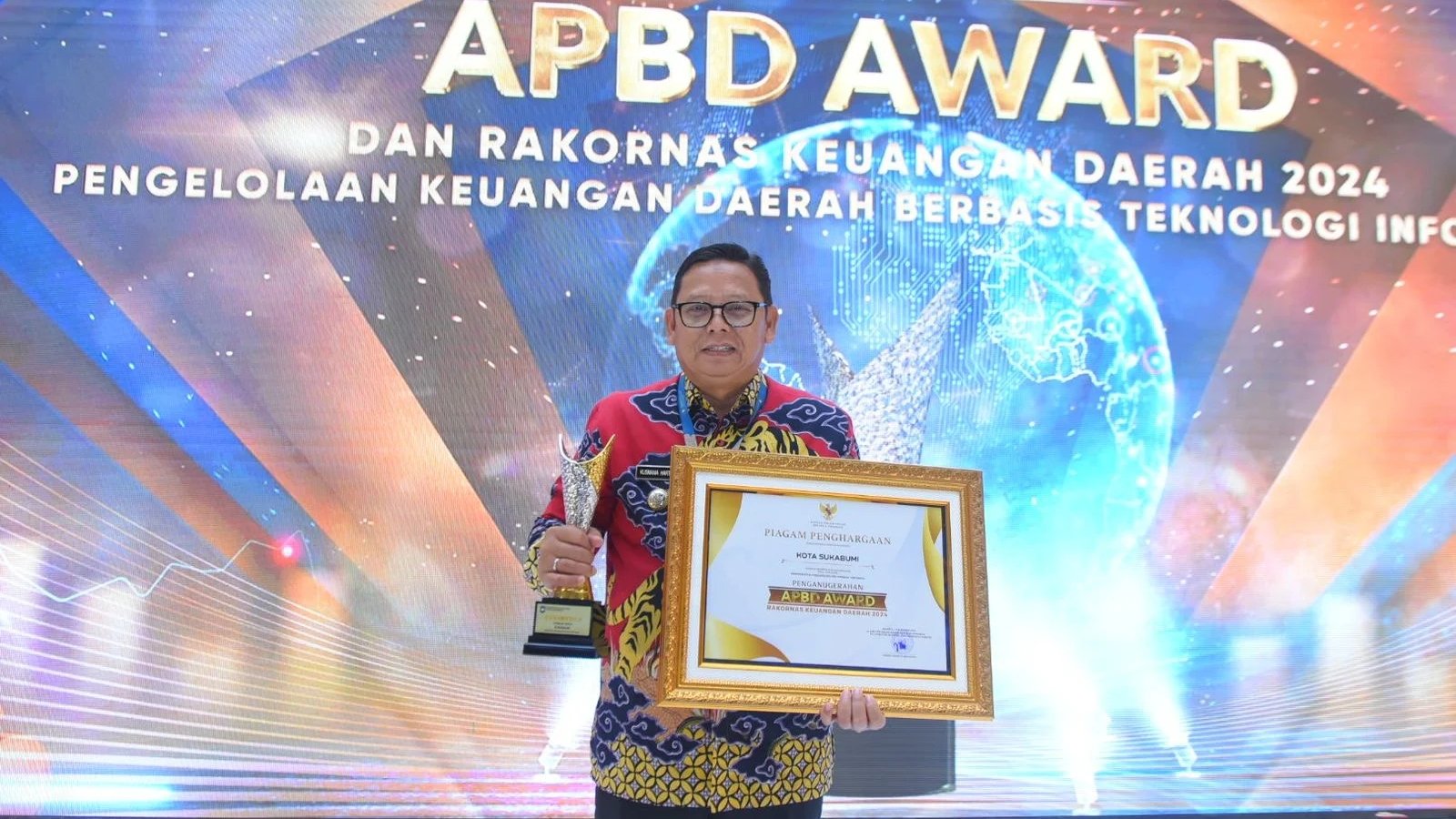 Pj Wali Kota Sukabumi, Kusmana Hartadji, menerima langsung penghargaan APBD Award 2024 dari Kemendagri, pada Rabu, 18 Desember 2024. Foto: Dokpim Kota Sukabumi.