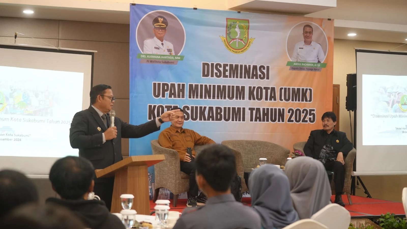 Pj Wali Kota Sukabumi, Kusmana Hartadji, saat memberikan sambutan dalam Diseminasi UMK tahun 2025 yang berlangsung di salah satu hotel di Jalan Siliwangi, pada Kamis, 19 Desember 2024. Foto: Dokpim Kota Sukabumi.