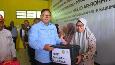 Pj Wali Kota Sukabumi, Kusmana Hartadji, menyalurkan bantuan tahap kedua kepada warga terdampak bencana di Kabupaten Sukabumi, pada Selasa, 14 Januari 2025. Foto: Dokpim Kota Sukabumi.
